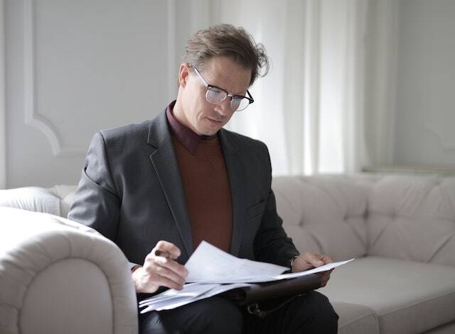 person sitting on couch reading over report